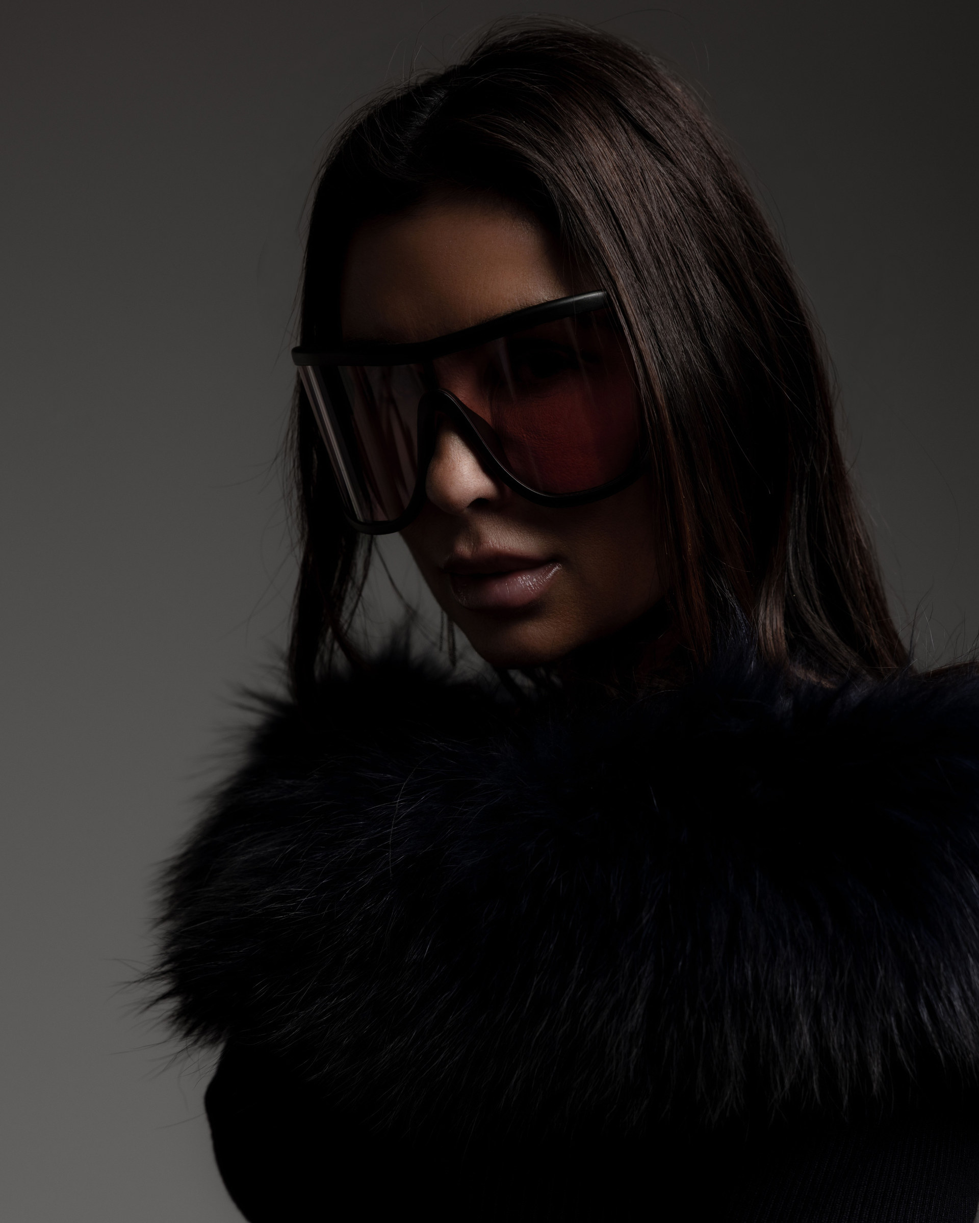 Shana Mak in the studio, red-lens glasses and fur collar